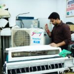Technician repairing an air conditioner unit in New Delhi workshop. - Photo by Multitech Institute on Pexels