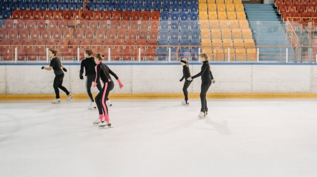 Five young skaters practice figure skating on an indoor ice rink, focusing on teamwork and technique. - Photo by Pavel Danilyuk on Pexels