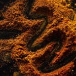 From above of creative design of smoked ground paprika and turmeric mixed together on black surface - Photo by https://kaboompics.com/ on Pexels