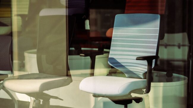 Contemporary office chairs displayed behind glass, offering modern ergonomic solutions for workspace. - Photo by aboodi vesakaran on Pexels