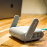 A sleek WiFi 6 router with antennas and cable on a wooden desk, perfect for modern home networks. - Photo by Pascal ???? on Pexels