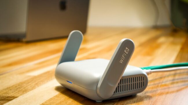 A sleek WiFi 6 router with antennas and cable on a wooden desk, perfect for modern home networks. - Photo by Pascal ???? on Pexels